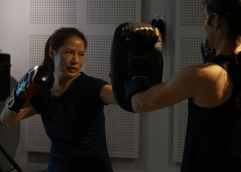 lady practicing muay thai with partner